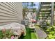 Cozy backyard area with artificial turf, plants, grill, and metal staircase at 10 Trapman St, Charleston, SC 29401