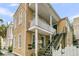 Charming multi-story home featuring a yellow exterior, upper balcony, and metal staircase at 10 Trapman St, Charleston, SC 29401