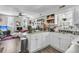 Open concept kitchen features white cabinets and eat-in countertop, leading to living room at 10 Trapman St, Charleston, SC 29401