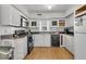 Functional kitchen features white cabinets, black appliances, and hardwood floors at 10 Trapman St, Charleston, SC 29401
