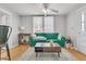 Bright living room with a cozy green sofa, wood floors, and lots of natural light at 10 Trapman St, Charleston, SC 29401