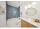 Bathroom features a tiled shower/tub, a wood vanity with white countertop, and a round mirror at 1014 E Erie Ave, Folly Beach, SC 29439
