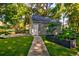 View of the detached garage featuring a garden with plants and flowers, in a well-maintained green lawn at 102 Cottonwood Dr, Summerville, SC 29483