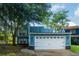 Exterior view of a two-story blue house with a two-car garage, featuring mature landscaping at 104 Queens Ct, Summerville, SC 29485