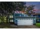 Charming blue two-story home featuring a white garage door and lush landscaping at 104 Queens Ct, Summerville, SC 29485