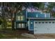 Charming blue two-story home featuring a white garage door and lush landscaping at 104 Queens Ct, Summerville, SC 29485