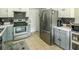 Well-lit kitchen with stainless steel refrigerator and appliances and ample countertop space at 104 Queens Ct, Summerville, SC 29485
