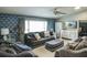 Comfortable living room with a plush sofa, patterned wallpaper, and ample natural light at 104 Queens Ct, Summerville, SC 29485