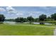 Picturesque pond view, surrounded by a lush green lawn and mature trees at 104 Queens Ct, Summerville, SC 29485