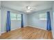 Bright bedroom with two windows, ceiling fan, hardwood floors and blue blackout curtains at 108 Reardon St, Moncks Corner, SC 29461