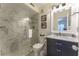 Modern bathroom featuring a glass shower door, beautiful marble tile, and dark vanity at 109 Carolina Blvd, Isle of Palms, SC 29451