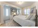 Bright bedroom with a decorative iron bed frame, built-in shelving, and plantation shutters at 109 Carolina Blvd, Isle of Palms, SC 29451
