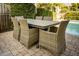 Inviting outdoor dining area with wicker chairs and a table next to the sparkling pool, perfect for al fresco meals at 109 Carolina Blvd, Isle of Palms, SC 29451