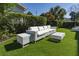 Stylish outdoor seating area featuring a comfortable white wicker sofa set on a lush green lawn, ideal for relaxation at 109 Carolina Blvd, Isle of Palms, SC 29451