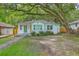 Inviting single-story white brick house featuring a green door and complemented by mature trees and partial lawn at 1188 Camden St, North Charleston, SC 29405