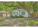 Charming single-story white brick home with a green door, surrounded by lush greenery and mature trees at 1188 Camden St, North Charleston, SC 29405