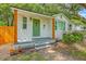 Charming house with a well-maintained yard, stone walkway, a green door, and a white brick facade at 1188 Camden St, North Charleston, SC 29405