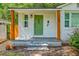Inviting front porch featuring an eye-catching green door, rustic wood posts, and fresh landscaping at 1188 Camden St, North Charleston, SC 29405