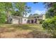 Backyard with home and garage featuring yard with scattered leaves, a screened in porch, and lush foliage at 1525 Westmoreland Ave, Charleston, SC 29412