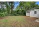 Backyard view of the home, showcasing a grassy area, partial fence, and garage with foliage at 1525 Westmoreland Ave, Charleston, SC 29412