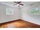 A bright bedroom featuring hardwood floors, a ceiling fan, and two windows offering natural light at 1525 Westmoreland Ave, Charleston, SC 29412