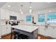 Bright, modern kitchen with white cabinets, subway tile backsplash, island with seating, and stainless steel appliances at 1525 Westmoreland Ave, Charleston, SC 29412