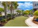 Beautifully landscaped backyard with artificial turf, a stone walkway, and a cozy fire pit area for relaxation at 1530 Willtown St, Daniel Island, SC 29492