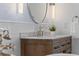 Bathroom vanity with white marble countertop, wooden cabinets, brushed gold faucet, and decorative plant at 1530 Willtown St, Daniel Island, SC 29492