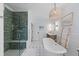 Luxurious bathroom features a freestanding tub, walk-in shower with green tile, and elegant décor at 1530 Willtown St, Daniel Island, SC 29492