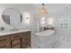 Elegant bathroom with double vanities, a freestanding tub, decorative wallpaper, and stylish fixtures at 1530 Willtown St, Daniel Island, SC 29492