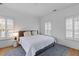 Bright bedroom with hardwood floors, a plush bed with decorative pillows, and shuttered windows for ample light at 1530 Willtown St, Daniel Island, SC 29492