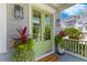 Charming home exterior with a welcoming green front door flanked by potted plants and stylish lighting fixtures at 1530 Willtown St, Daniel Island, SC 29492