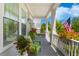 Charming front porch with green seating, vibrant potted plants, and a welcoming American flag display at 1530 Willtown St, Daniel Island, SC 29492