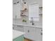 White cabinetry and countertops, paired with open shelving, combine for a bright and efficient kitchen detail at 1530 Willtown St, Daniel Island, SC 29492