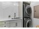 Modern laundry room with stacked washer and dryer, white quartz countertops, and subway tile backsplash at 1530 Willtown St, Daniel Island, SC 29492