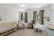 Bedroom with a crib, comfortable chair, large window and neutral walls at 1543 Bluewater Way, Charleston, SC 29414