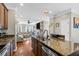 Gourmet kitchen with granite counters, stainless steel appliances, and hardwood floors, open to the living space at 1543 Bluewater Way, Charleston, SC 29414