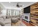 Stylish living room featuring a fireplace with wood paneling, a large sectional sofa, and hardwood floors at 1543 Bluewater Way, Charleston, SC 29414