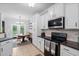 Charming eat-in kitchen has white cabinetry, a wooden table, and easy access to outdoor living space at 158 Balsam Cir, Summerville, SC 29485