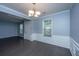 Elegant dining room boasts hardwood floors, wainscoting, and a modern chandelier, connecting seamlessly to other living spaces at 1629 Jorrington Street St, Mount Pleasant, SC 29466