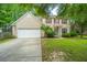 Charming two-story home with beige siding, red shutters, a well-manicured lawn, and an attached two-car garage at 1629 Jorrington Street St, Mount Pleasant, SC 29466