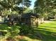 Back exterior of a brick home featuring a deck, screened porch, and a lush green lawn surrounded by mature trees at 1807 Perch Rd, Moncks Corner, SC 29461