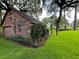View of a brick detached garage with beautiful surrounding green grass, plants, and trees at 1807 Perch Rd, Moncks Corner, SC 29461