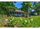 Charming single-Gathering home with a welcoming porch and lush landscaping, surrounded by vibrant flowering plants and mature trees at 1872 Staffwood Rd, Johns Island, SC 29455