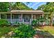 Inviting home featuring a covered porch, crisp white railings, and beautifully manicured landscaping at 1872 Staffwood Rd, Johns Island, SC 29455
