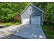 Two-car detached garage with white doors and a driveway, framed by lush greenery at 1872 Staffwood Rd, Johns Island, SC 29455