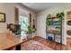 Bright home office with a view, featuring a large desk with shelving, and hardwood floors at 1872 Staffwood Rd, Johns Island, SC 29455