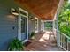 The home features a welcoming porch with painted wood floors and ceiling, gray walls, and is accented with potted plants at 1872 Staffwood Rd, Johns Island, SC 29455