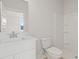 Bright bathroom features a white vanity, toilet, and shower with built-in shelving at 205 Bilge Rd, Ridgeville, SC 29472