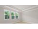 Bedroom with tray ceiling, three windows offering a view of surrounding trees, and neutral walls at 205 Bilge Rd, Ridgeville, SC 29472